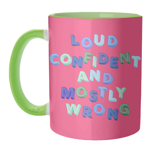 A pink ceramic mug with a light green handle and interior, featuring the text 'LOUD CONFIDENT AND MOSTLY WRONG' in colorful bubble letters.